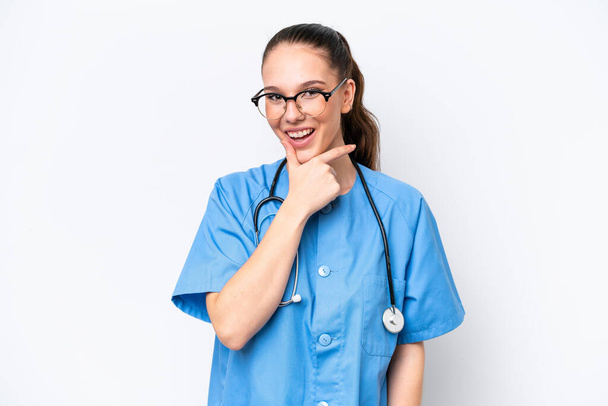 Nuori valkoihoinen kirurgi lääkäri nainen eristetty valkoisella taustalla hymyillen - Valokuva, kuva