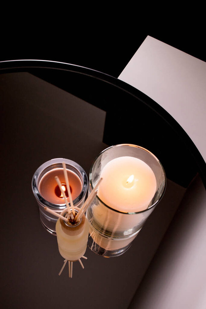 Aroma diffuser and scented candles on table with reflectio. Romantic setting. - Foto, imagen