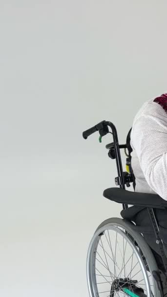 młody przystojny na wózku inwalidzkim siedzi na białym tle jest miejsce na tekst doświadczania cierpienia  - Materiał filmowy, wideo