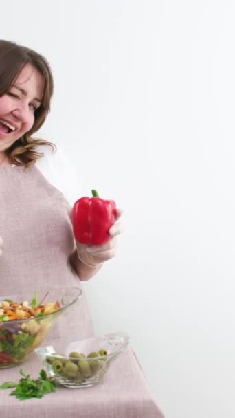 красива жінка перець показує червоний болгарський перець в руці з іншою рукою показує великий палець вгору класу кілька разів вказуючи на салат вегетаріанський смачний
  - Кадри, відео