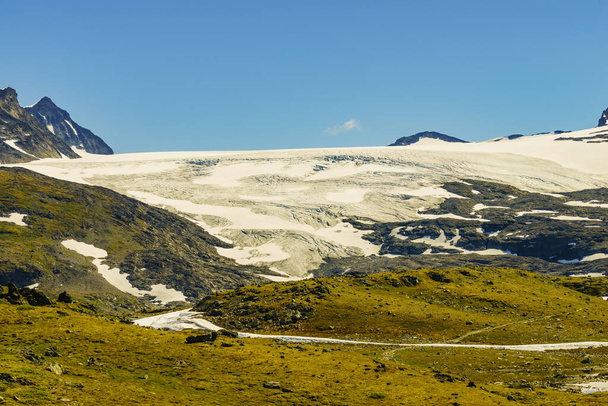 Paisaje montañoso en verano con picos nevados y glaciares. Ruta turística nacional 55 Sognefjellet entre Lom y Gaupne, Noruega. - Foto, imagen