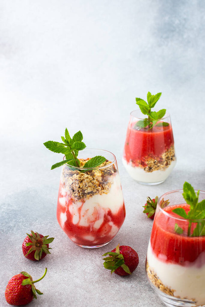 Healthy tasty breakfasts, glasses with granola and yogurt and strawberry smoothie - Foto, immagini
