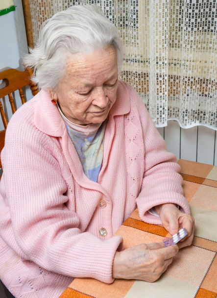 Vieja mujer triste sosteniendo pastillas
 - Foto, imagen