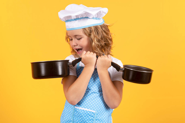 Kid chef cook with cooking pot stockpot. Cooking children. Chef kid boy making healthy food. Portrait of little child in chef hat isolated on studio background. Kid chef. Cooking process - Fotoğraf, Görsel