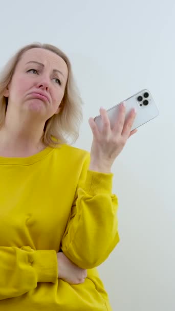 Hoşnutsuz bir kadın telefonda hoşnutsuz bir şekilde konuşurken üzgün hisseder. Yüksek kalite 4k görüntü - Video, Çekim