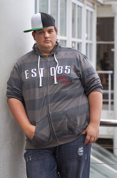 Plus size, young guy and portrait outdoor with hipster and urban style feeling serious. Student, gen z fashion and cool clothing of a heavy male person with youth and confidence with hands in pocket. - Foto, Imagen