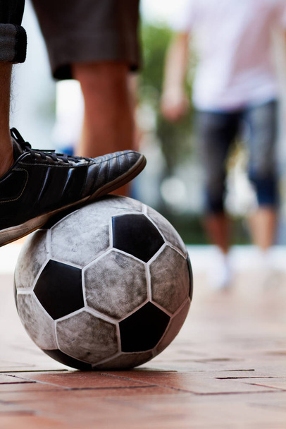 Sports, street and feet of a person for soccer, game and training for athlete. City, sneakers and legs of a man with a football for sport, exercise and urban fitness in the road while playing a match. - Photo, image