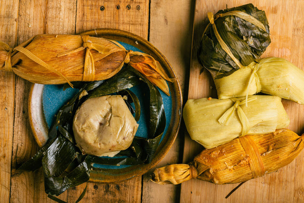Tamales, comida típica mexicana hecha de maíz sobre una mesa de madera. - Foto, imagen