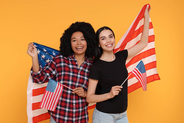 4th of July - Independence Day of USA. Happy women with American flags on yellow background - Foto, Bild