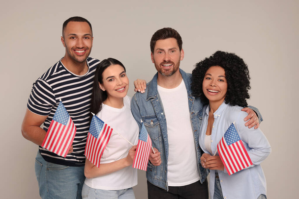 4th of July - Independence Day of USA. Happy friends with American flags on grey background - Foto, Imagem