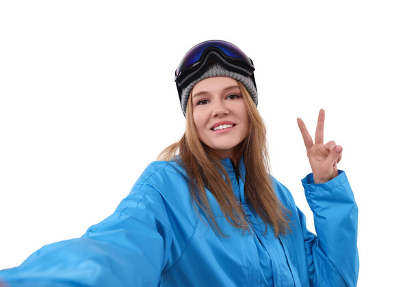 Beautiful woman in ski goggles taking selfie on white background - Foto, Imagen