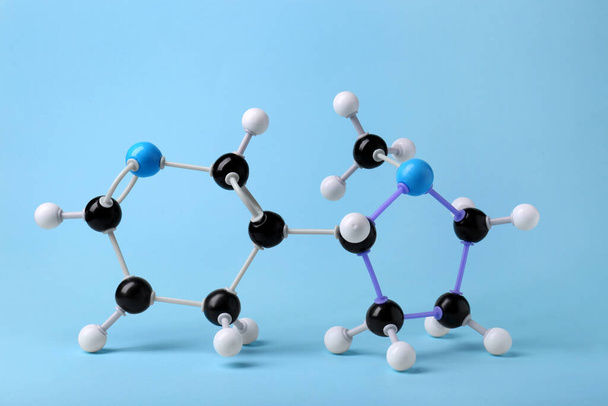 Nikotinmolekül auf hellblauem Hintergrund. Chemisches Modell - Foto, Bild