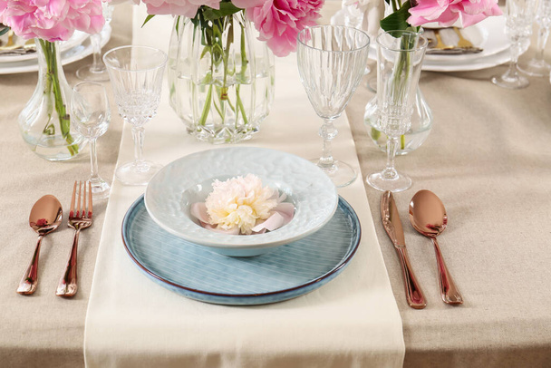 Stylish table setting with beautiful peonies and golden cutlery - Foto, Imagem