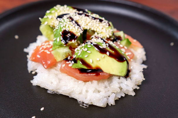 Sushi waffles are crispy rice cooked in a waffle iron with salmon. Trending food, hybrid food - Photo, Image