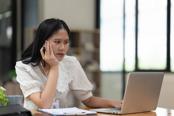 Financier une femme asiatique travaille, utilise un ordinateur portable, fait un rapport à une société de financement. Concept comptable et financier. - Photo, image