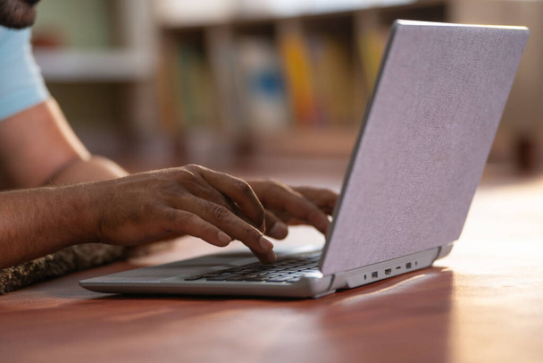 Крупним планом знімок людини, що використовує ноутбук, лежачи на підлозі вдома концепція кіберпростору, розкручування інтернету та серфінгу
. - Фото, зображення