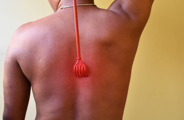 Schienale di un uomo indiano con un bastone per graffiare la schiena aiuto graffiare l'area prurito della pelle da Dermatite, Su sfondo bianco. Concetto di assistenza sanitaria e malattia della pelle. - Foto, immagini