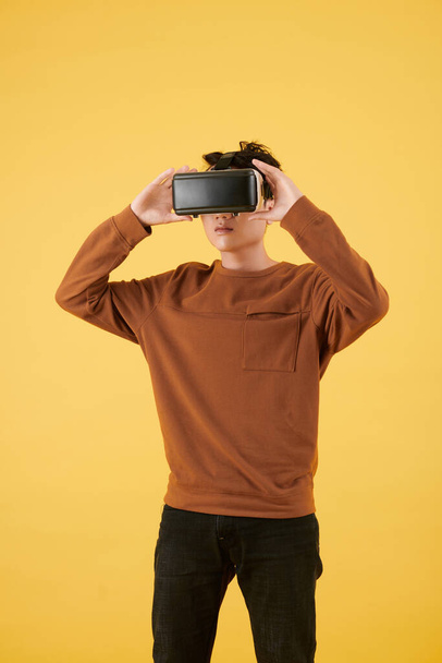 Retrato de estudio de un hombre joven con auriculares de realidad virtual al explorar metáfora - Foto, imagen