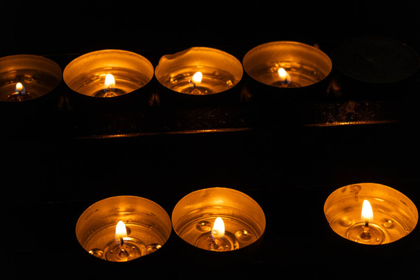 A lot of burning candles in the temple in the dark. The concept of religion, prayer and God - Photo, Image