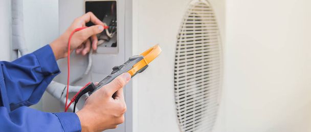 Légkondicionáló, HVAC szerviztechnikus mérőműszerekkel ellenőrzi a hűtőközeget és hűtőközeget ad hozzá. - Fotó, kép