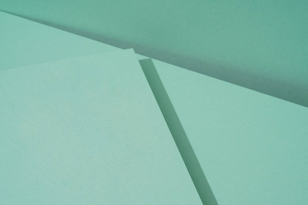 Bunter Hintergrund aus grünem Papier mit Schatten. Abstrakte Geometrie - Foto, Bild
