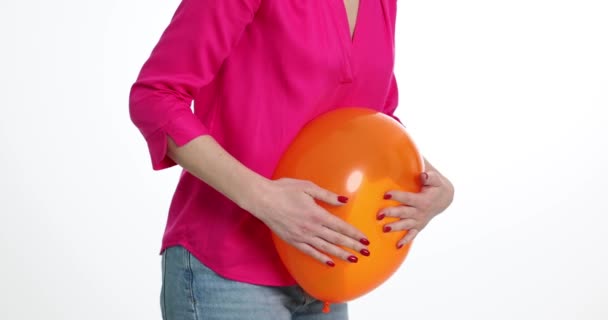 Žena se drží nemocného žaludku s balónem na bílém pozadí. Flatulence a nadýmání a nadměrné hromadění plynů ve střevech - Záběry, video