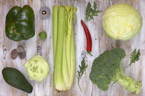 Conjunto de verduras sobre fondo de madera pintada de blanco: colinabo, pimienta, col, brócoli, aguacate, rúcula, coles de Bruselas, apio
. - Foto, imagen