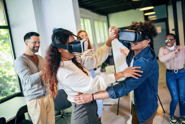 Travailleurs multiethniques qui s'amusent dans leur travail au bureau en portant des lunettes VR - Photo, image