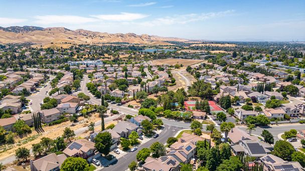 Immagini aeree su una comunità di Antiochia, California con case, auto, strade e alberi. Con un cielo blu e spazio per il testo - Foto, immagini