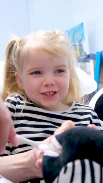 стоматолог показує дитині, як чистити зуби іграшкова зебра дівчина виглядає усміхненою стоматологією для дітей дівчина бере пензлик, а також чистить зуби правильно
  - Кадри, відео