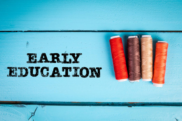 Early Education Concept. Colorful spools of thread on a blue wooden background. - Fotoğraf, Görsel