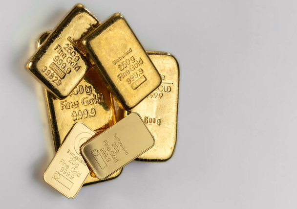Αρκετές ράβδοι χρυσού διαφορετικού βάρους σε μια γκρίζα επιφάνεια. - Φωτογραφία, εικόνα