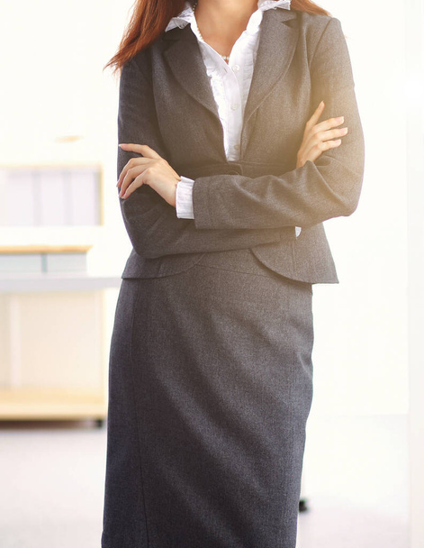 Portrait of business woman standing with crossed arms in office - 写真・画像