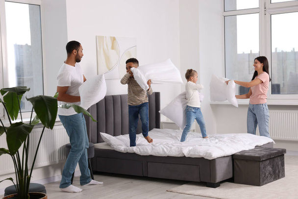 Happy international family having pillow fight at home - Фото, изображение