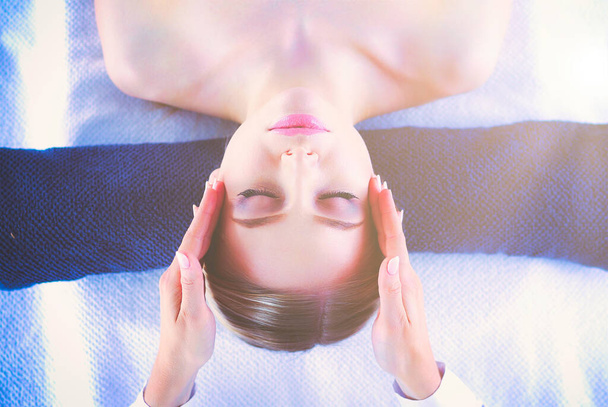 Young woman lying on a massage table,relaxing with eyes closed. Woman. Spa salon. - 写真・画像