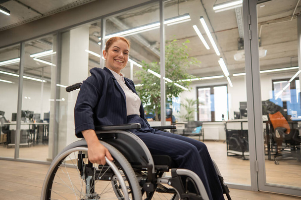 Caucasian woman wheelchair in open space office - Фото, зображення