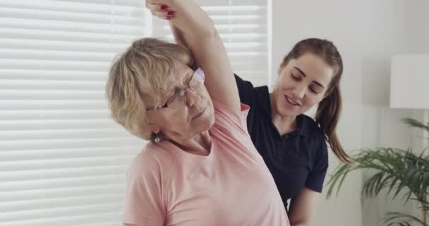 Senior patient, physiotherapist and stretching arms for rehabilitation and physical therapy. Elderly woman with a chiropractor for healing, health and wellness with physio exercise and healthcare. - Metraje, vídeo