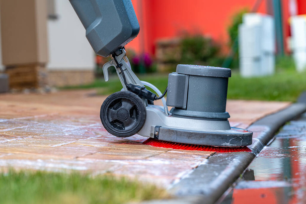 handmatig reinigen van betonnen en stenen trottoirs met een mechanische borstel. Hoge kwaliteit foto - Foto, afbeelding