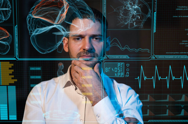 A bearded man sits in the dark in front of a virtual menu. Human brain research - Φωτογραφία, εικόνα