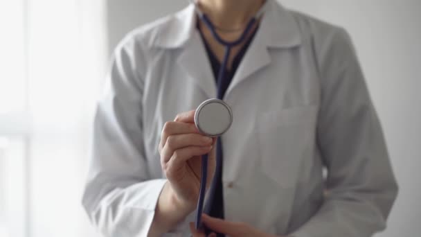 Doctor holds his stethoscope and moves it forward for examining patient. Professional healthcare assistance service concept, medicine. - Filmati, video