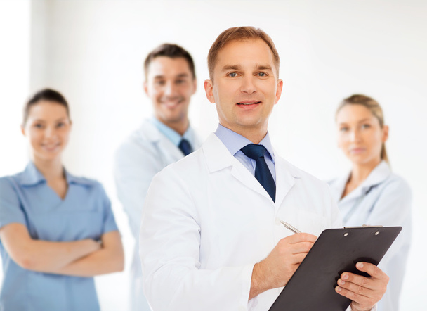 smiling male doctor with clipboard - Foto, Bild
