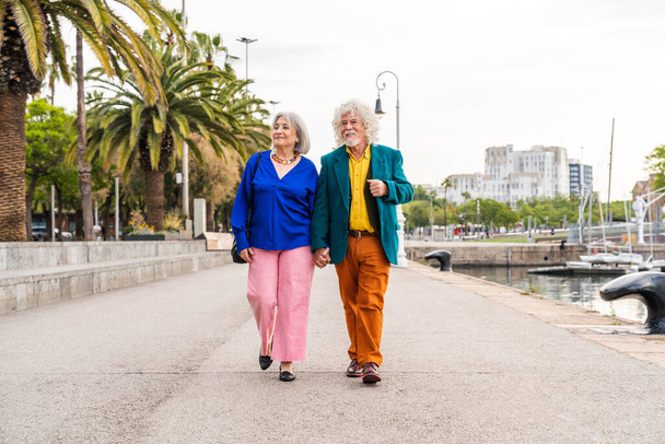 Senior couple of old people dating outdoors - Married elderly man and woman in love spending time together - Grandparents having fun strolling in the city - Photo, Image