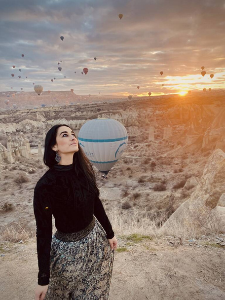 beautiful young woman and balloons in cappadocia, turkey. - Foto, afbeelding
