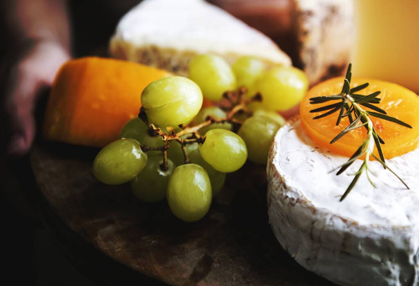 A sajt és a zöld szőlő, egy fából készült tál étel fotózás recept ötlet, variáció - Fotó, kép