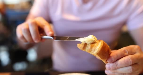 Perinteinen ranskalainen aamiainen tuoretta croissant ja levittää voita leipää. Aamiainen tai lounas kahvilassa käsite - Materiaali, video