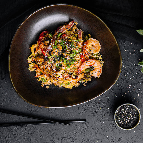 Vista superior de arroz frito con mariscos y verduras preparados en wok chino - Foto, Imagen