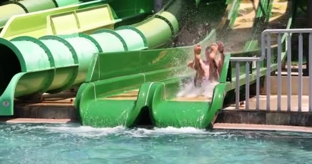 Happy man have fun in water park and rides down hill. Cheerful summer holiday tourist - Footage, Video