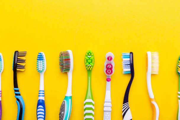 Toothbrushes on a yellow background. Health care, dental hygiene. Space for text. Top view. - Foto, imagen