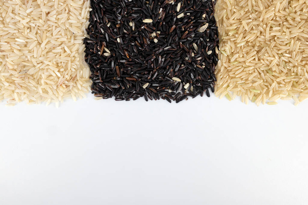 organic hom mali half-milled rice, organic hom mali brown rice and riceberry on white table background. Jasmine rice and Riceberry it's variety rice that originates from Thailand. - Fotografie, Obrázek