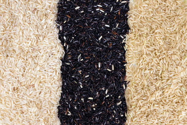 organiczny hom mali ryż półbielony, organiczny hom mali brązowy ryż i ryż na białym tle stołu. Jasmine ryż i Riceberry to odmiana ryżu, który pochodzi z Tajlandii. - Zdjęcie, obraz